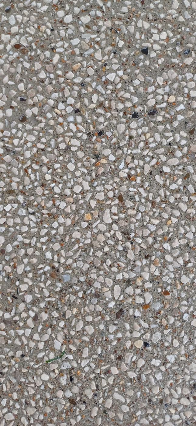 Lichte kiezels in uitgewassen beton