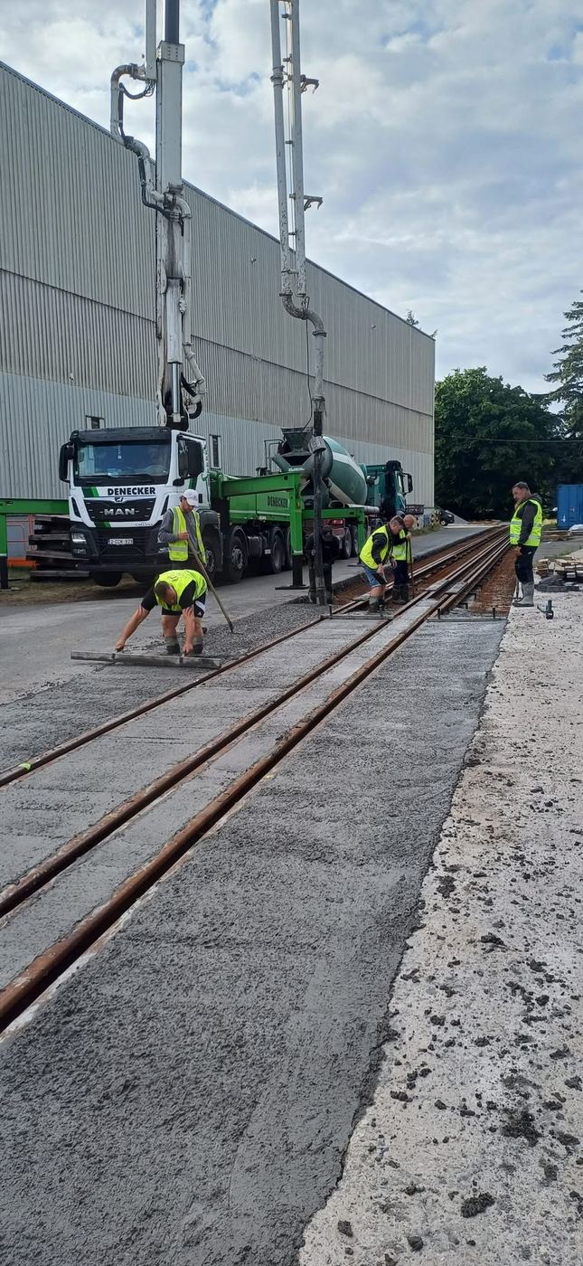 De ploeg van Slosse Yves stort beton op een spoorwerf